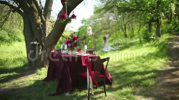 室外婚礼桌装饰和年轻新娘手中捧着一束美丽的婚礼花视频的预览图