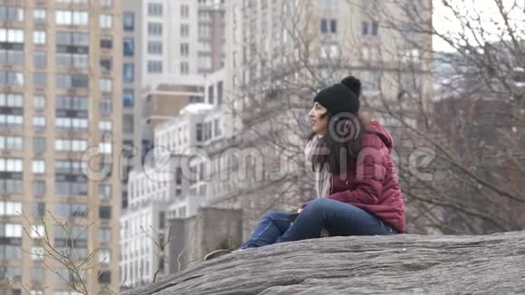 年轻女子在纽约中央公园的岩石上放松视频的预览图