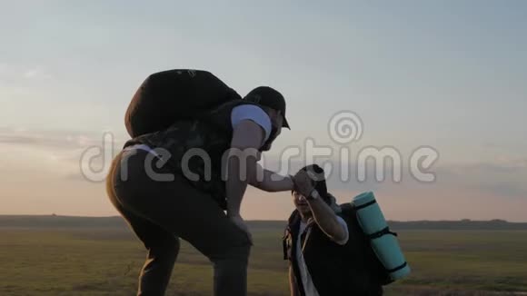 攀爬帮助队友攀爬拿着背包的人伸出一只帮助他的朋友的手帮助朋友视频的预览图