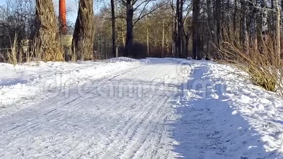 冬天把白雪皑皑的道路穿过森林视频的预览图