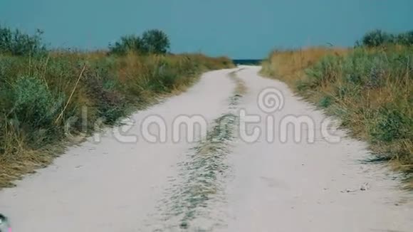 苗条的女孩经过沙质路去海滩视频的预览图