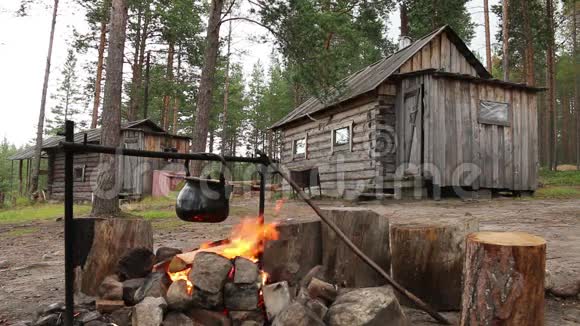 在森林小屋附近的小屋附近有一群人在营火上吃过饭视频的预览图