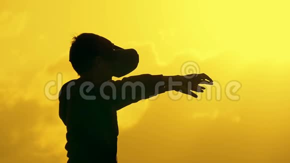 日落时在公园里用vr眼镜伸出手臂的男孩的肖像博克赫视频的预览图