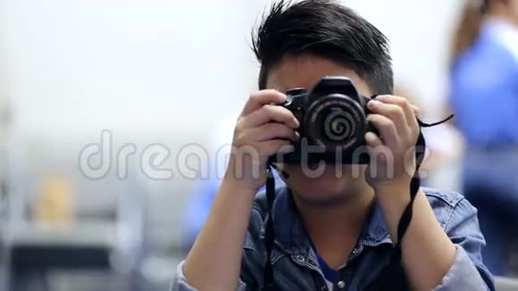 亚洲男孩用数码单反相机拍照视频的预览图