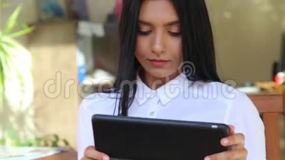拉丁女商人手里拿着平板电脑穿着白色衬衫视频的预览图