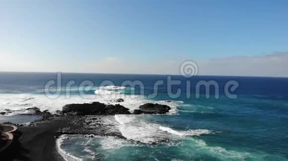 大西洋波浪在山的背景和日落在特内里费岛金丝雀群岛和美丽的自然一堆石头视频的预览图