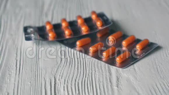 手将药片以橙色胶囊形式折叠在桌子上视频的预览图