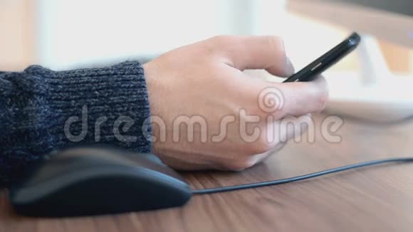 在电脑上工作的人用手点击鼠标和使用智能手机视频的预览图