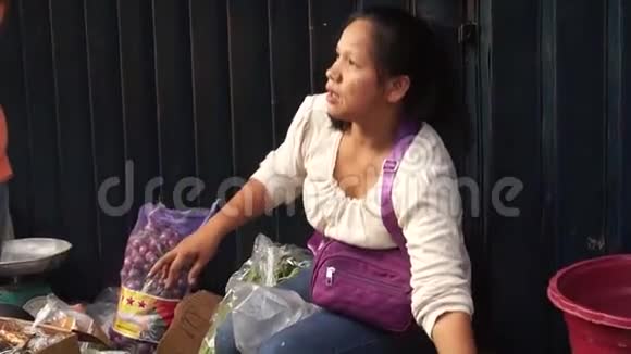 女人沿着城市人行道卖蔬菜视频的预览图