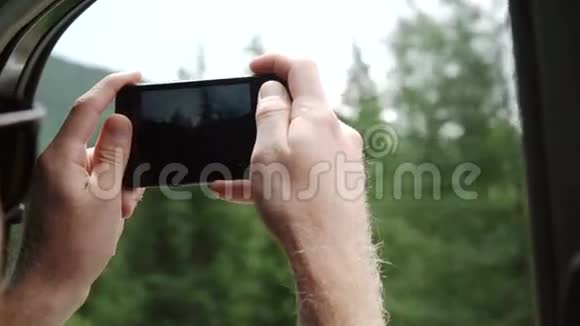 年轻夫妇开车和用智能手机拍照的背景视频的预览图