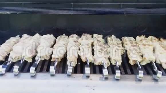 生肉在烤架上烹饪新鲜的肉片在串上螺纹烤架上烤制的烤肉煮肉时会变糟视频的预览图