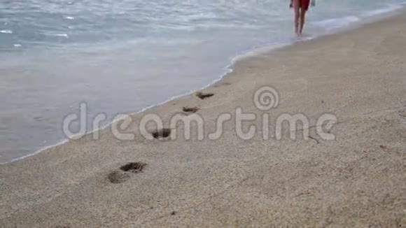 日落时分在地中海海滩上独自散步的轻松女孩视频的预览图