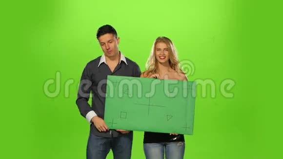 精力充沛的情侣举着一个空白的牌子绿色的视频的预览图