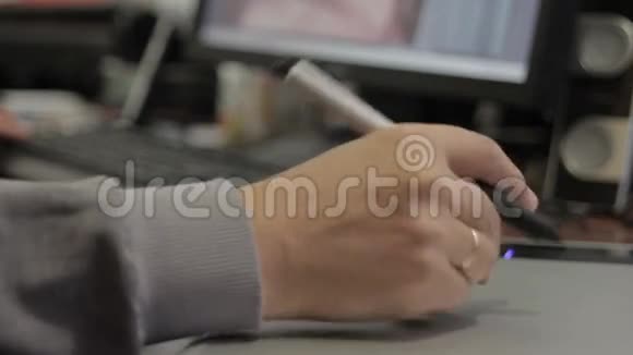 摄影师在笔记本电脑上绘制和润色图像使用数字平板电脑和手写笔特写男人的手视频的预览图