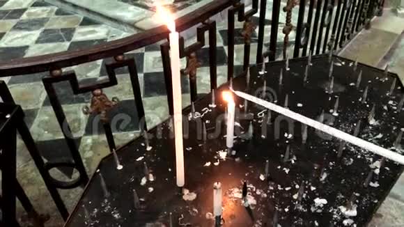 妇女在教堂里点燃祈祷蜡烛也就是祭祀或纪念蜡烛视频的预览图