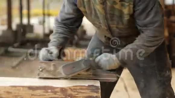 建筑工人为建筑工程刨一块木头施工打磨电动手平面反对视频的预览图