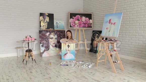 才华横溢的女艺术家坐在工作室的地板上画画视频的预览图