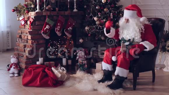 圣诞老人坐在圣诞树旁手里拿着满满一袋礼物视频的预览图