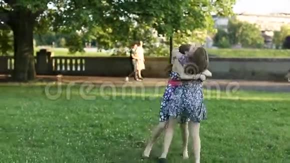 少女女友在公园相遇快乐地拥抱完全生长的镜头视频的预览图