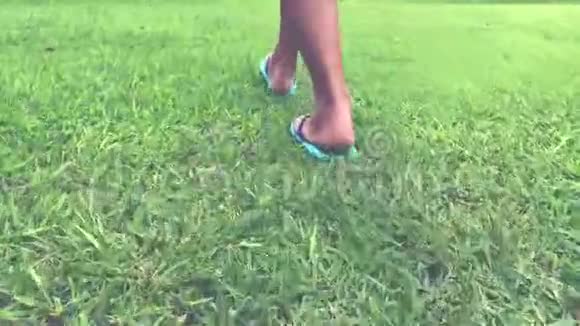 在公园里散步的女人女人的腿在草地上印度尼西亚巴厘热带岛屿视频的预览图