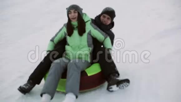 可爱的男人和女孩在冬天滑着雪管上的雪山视频的预览图