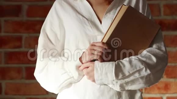 穿着白衬衫拿着旧书的女人视频的预览图