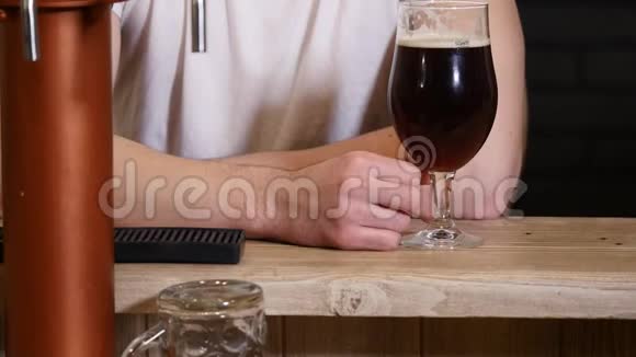 男子喝啤酒和享受饮料在酒吧高清特写慢镜头视频男客人用眼镜品尝啤酒视频的预览图