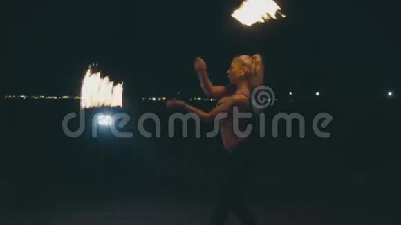 一个漂亮的金发女人晚上在火上表演视频的预览图