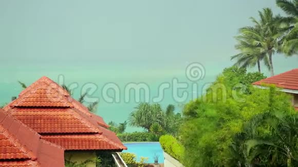 热带雨滴落在泰国苏梅岛的屋顶上海景和彩虹4k3840x2160视频的预览图
