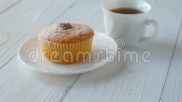 纸杯蛋糕和一杯咖啡放在白色的木桌上去集中注意力视频的预览图