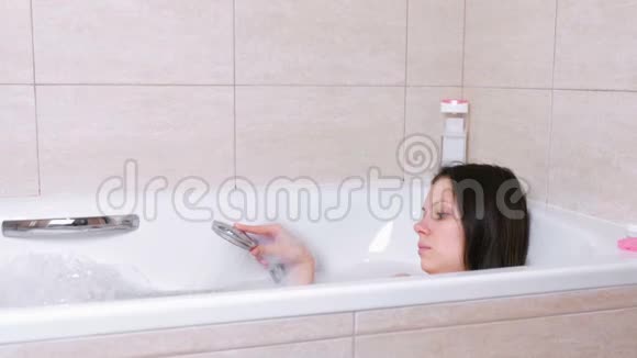女人正在用泡沫洗澡她从淋浴中倒出她的身体水视频的预览图