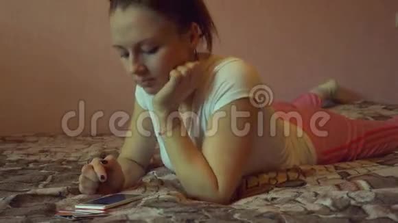 一个幸福的女人在她可爱的卧室里发短信的画像视频的预览图