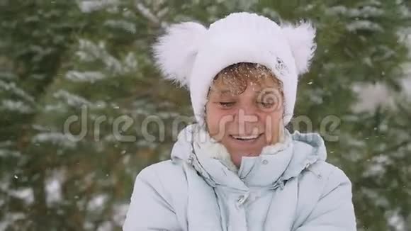 成熟的女人在冬天在公园里慢慢地扔雪花玩得很开心1920x1080视频的预览图
