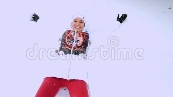 快乐的年轻女子在雪地里摔倒在缓慢的运动中享受着降雪1920x1080视频的预览图