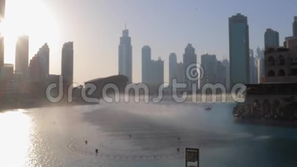 迪拜首都哈利法塔附近的喷泉在日落时分被城市照亮视频的预览图