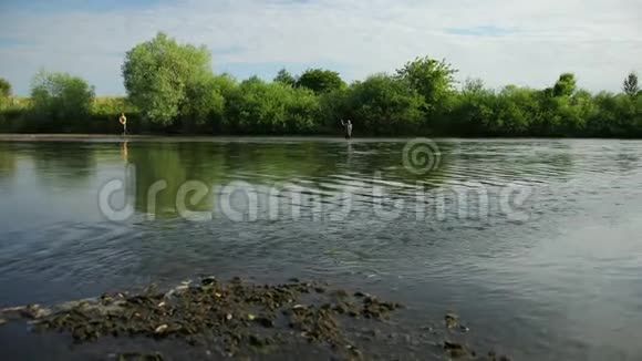 两个人在河上钓鱼站在水里一股小小的水流视频的预览图