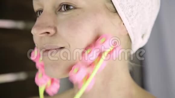漂亮的女人在家里做美容手术按摩式面部按摩视频的预览图