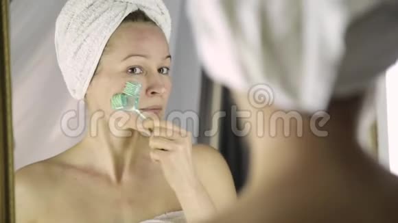 漂亮的女人在家里做美容手术按摩式面部按摩视频的预览图