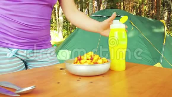 在野餐时女性用手把一个苹果切成块做水果沙拉视频的预览图