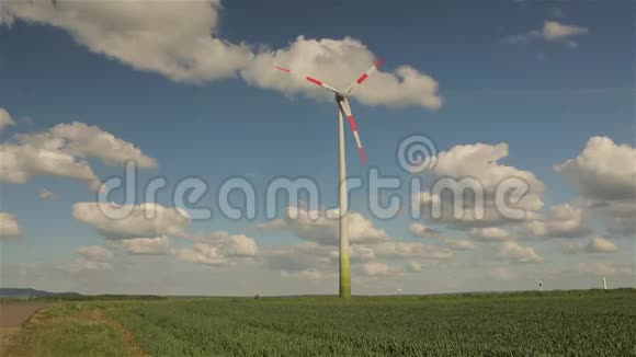 风力发电机背景下的云浮在天空大型风力发电机叶片的旋转视频的预览图