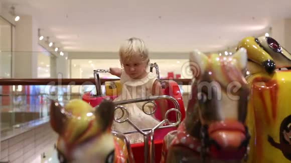 一个金发女郎坐在玩具马车上骑着马视频的预览图