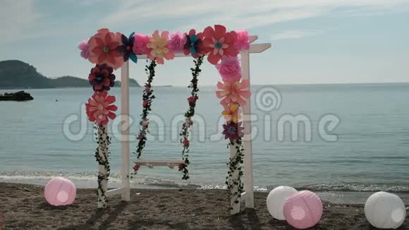 在海滨荡秋千空秋千装饰着鲜花和球视频的预览图