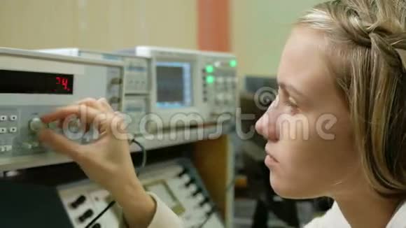 年轻的女工程师学生在实验室用电气仪器工作她小心翼翼地转动车轮时钟视频的预览图