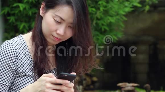 亚洲女人在花园里打电话聊天视频的预览图