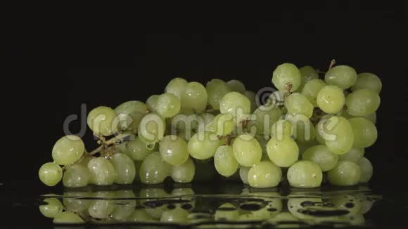 水流落在黑色背景上的一串葡萄上视频的预览图