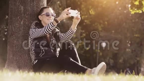 公园里的女人用手机拍照视频的预览图