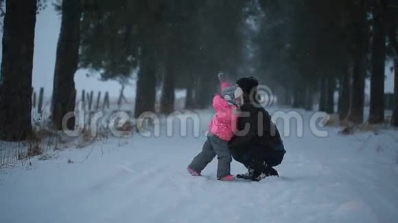 爸爸和女儿快乐地拥抱在冬天的公园里视频的预览图