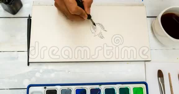 用黑色墨水在纸上画涂鸦用水彩画视频的预览图
