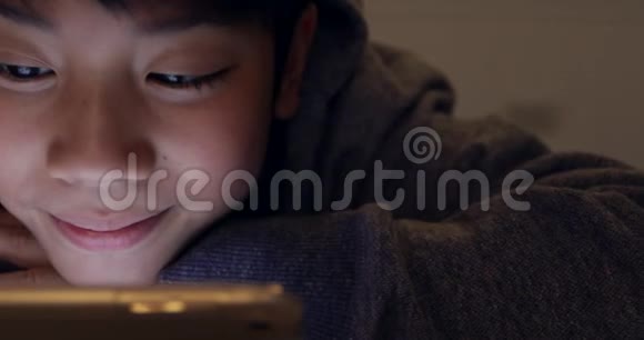 可爱的亚洲男孩使用平板电脑年轻的十几岁男孩在数字平板电脑上玩游戏带着微笑的脸视频的预览图