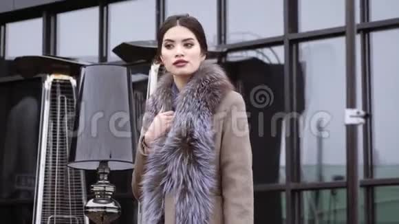 摄影的冬季大衣收藏为封面的杂志在一个漂亮的模特面前摆姿势视频的预览图